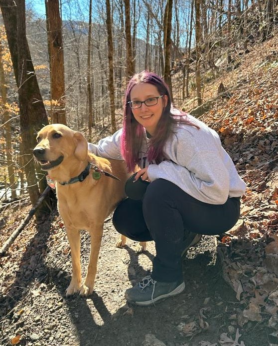 woman in woods with dog