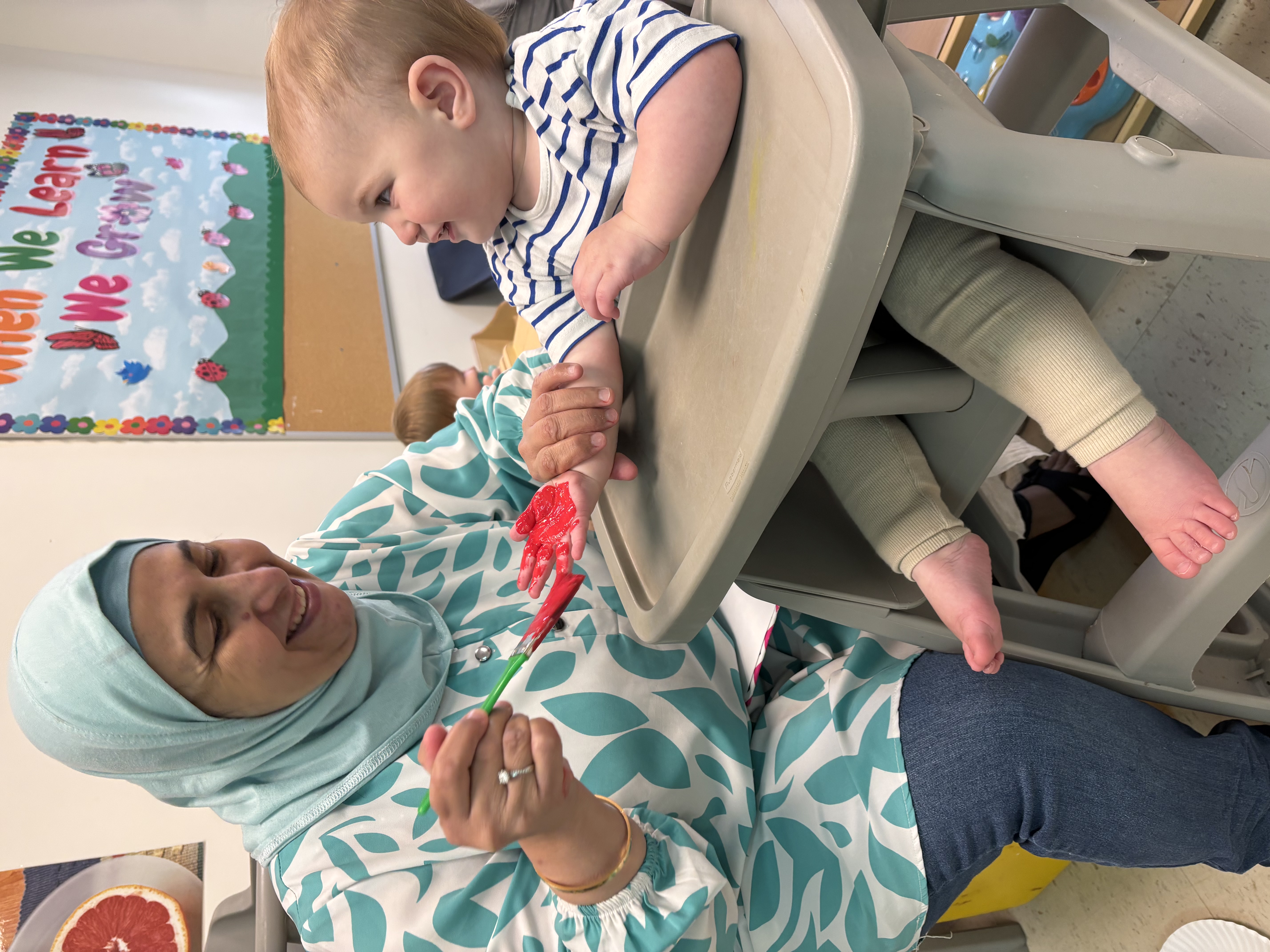 Woman feeding toddler in a high chair